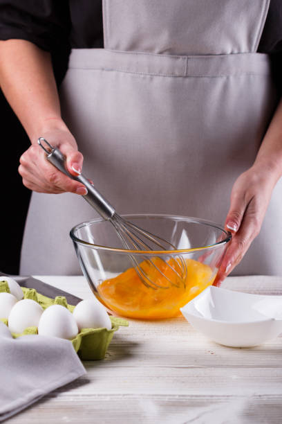 istock young woman in a gray aprons breaks the eggs 1144835723