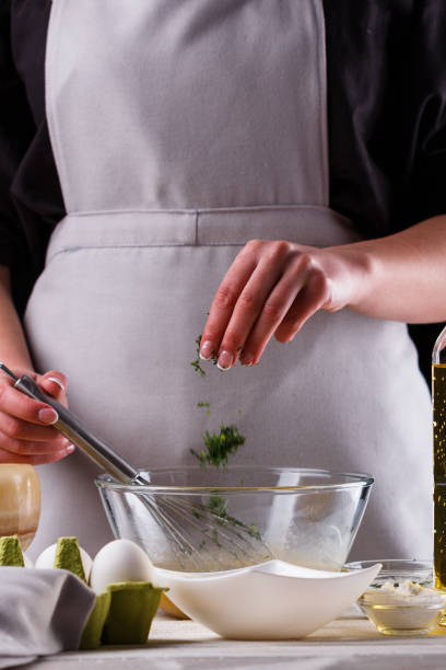 istock young woman in a gray aprons breaks the eggs 1144835868