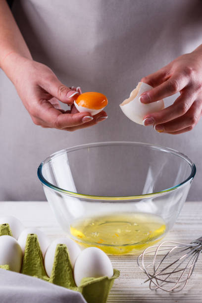 istock young woman in a gray aprons breaks the eggs 1144835987