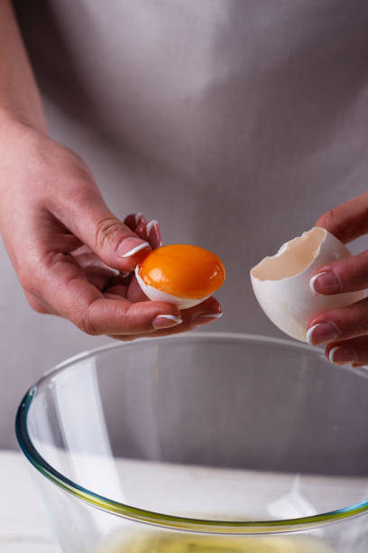 istock young woman in a gray aprons breaks the eggs 1144835994
