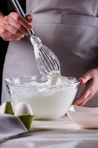 istock young woman in a gray aprons breaks the eggs 1144836059