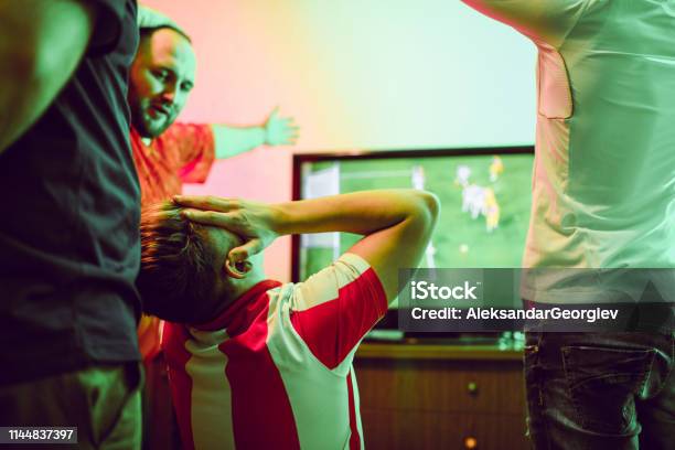Disappointed Male Watching Soccer Match With Friends Stock Photo - Download Image Now