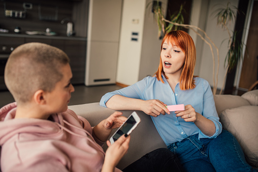 Young women using mobile phone and manicure set