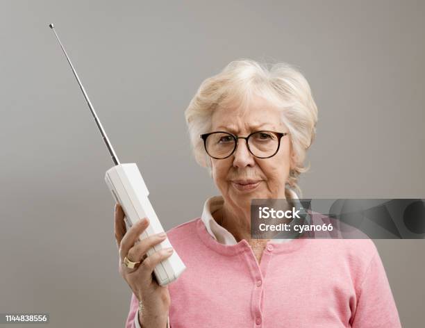 Frustrated Senior Woman Using An Old Telephone Stock Photo - Download Image Now - Anger, Telephone, Displeased