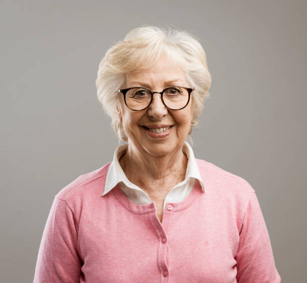 istock Happy senior woman posing on gray background 1144838763