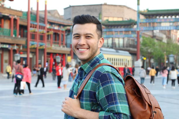 homem novo bonito que sorri na rua aglomerada asiática - vietnam market asia bird - fotografias e filmes do acervo