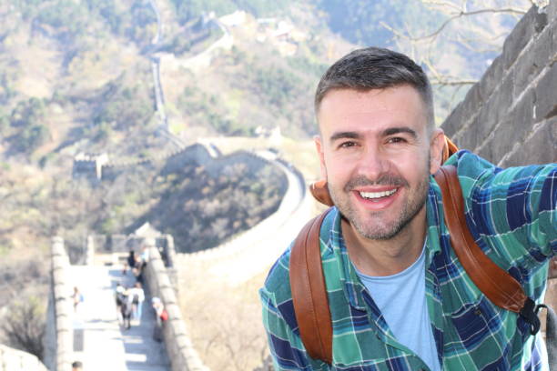 Handsome man taking a selfie in The Great Wall of China stock photo