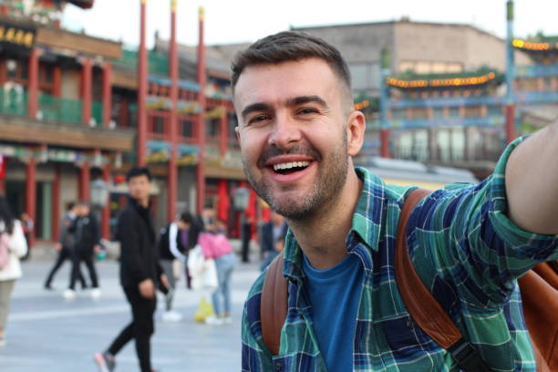 istock Cute white man taking a selfie in crowded Asian street 1144840428