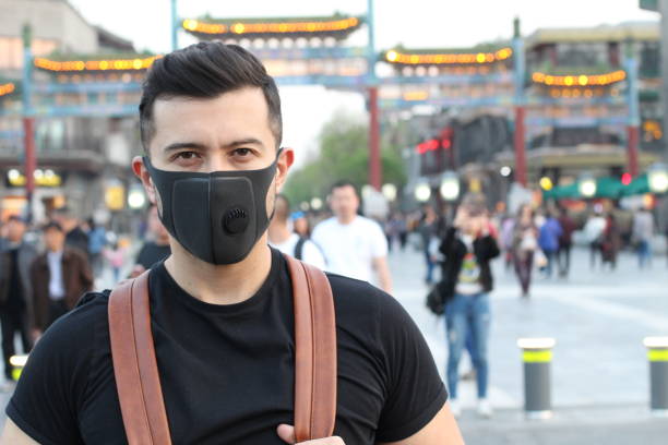 homme utilisant le masque de pollution en asie - beijing air pollution china smog photos et images de collection