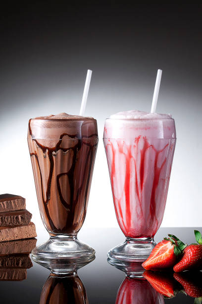 Strawberry milkshake and chocolate Milkshake on reflective background stock photo