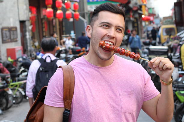 istock Man eating sugar-coated haws on a stick in China 1144841208