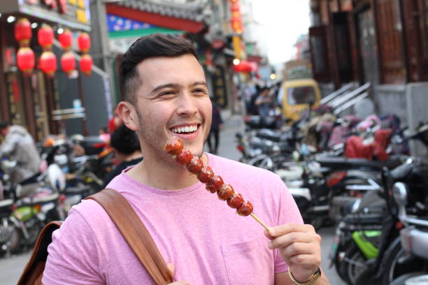 istock Man eating sugar-coated haws on a stick in China 1144841215