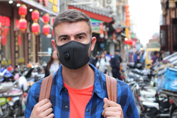 turista caucasiano que usa a máscara da poluição em ásia - smog china beijing pollution - fotografias e filmes do acervo