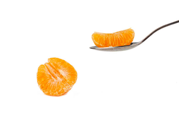 istock A spoon holds a slice of mandarin on a white background 1144842879