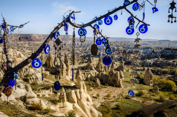 istock Evil eye talismans hang on a tree over volcanic rock landscape, 1144843400