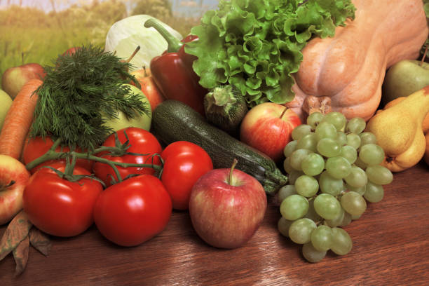 Various fresh vegetables and fruits on a wooden oak table. Fresh harvest, tomatoes, apples, carrots, pears, dill, grapes