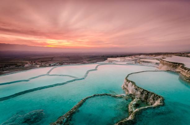 le carbonate traverse les bassins naturels au coucher du soleil, pamukkale - hierapolis photos et images de collection