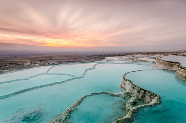 le carbonate traverse les bassins naturels au coucher du soleil, pamukkale - hierapolis photos et images de collection