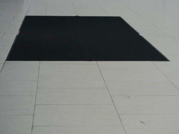 alfombra negra en el suelo de baldosas de piedra en frente de la puerta - rubber floor mat floor doormat fotografías e imágenes de stock