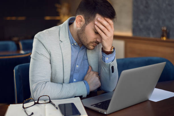 istock Exhausted businessman feeling pain after working on laptop. 1144849389