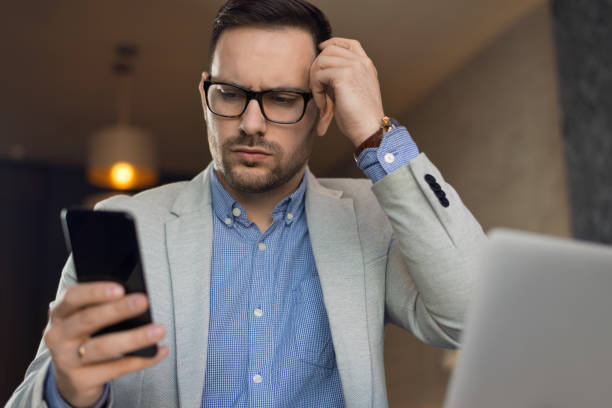 istock Worried businessman reading a text message on cell phone 1144849682