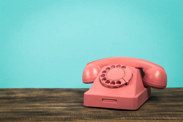 istock Vintage old telephone on wood table with turquoise wall background 1144851792