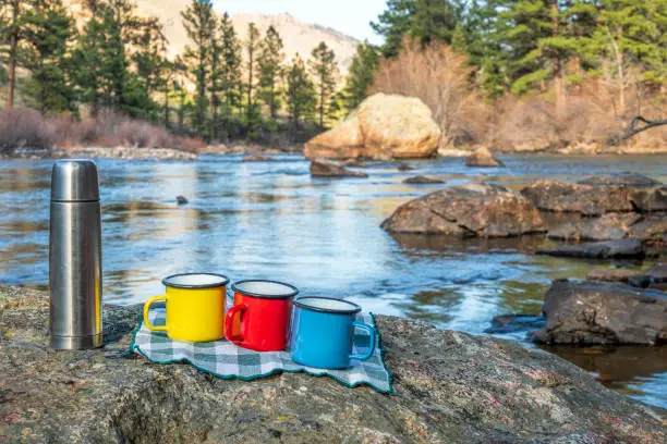 tea break or picnic on a shore of mountain river - Poudre River in Colorado, early spring scenery