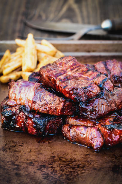 Bbq boneless beef ribs with barbecue sauce and potato wedges stock photo