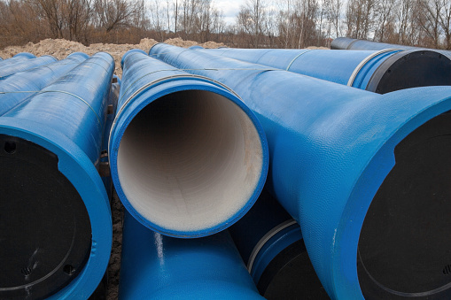 Stack of new blue pipes (tubes). Fluid conveyance. Pipeline construction.