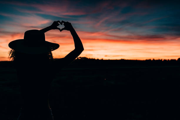 istock Woman silhouette in the beautiful sunset 1144856653