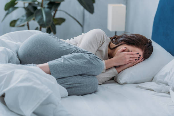 istock depressed woman lying in bed, crying and covering face with hands 1144858084