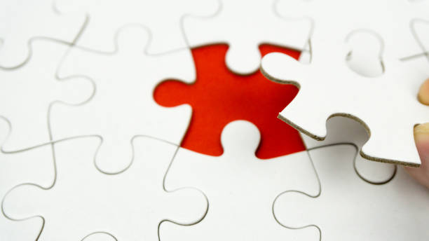 istock Hands placing last piece of a Puzzle 1144859524