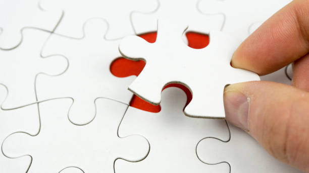 istock Hands placing last piece of a Puzzle 1144859546
