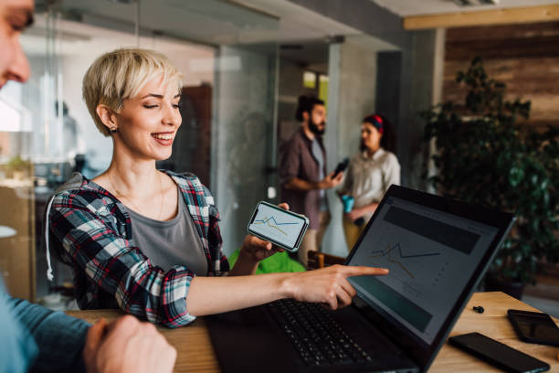 istock Young couple using phone and looking at laptop 1144859573