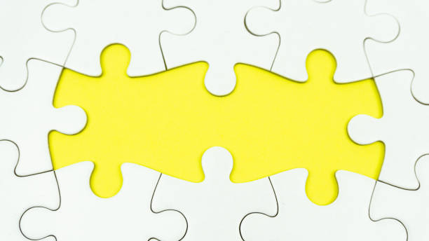 Uncompleted white jigsaw puzzle board Uncompleted white jigsaw puzzle board on yellow background uncompleted stock pictures, royalty-free photos & images