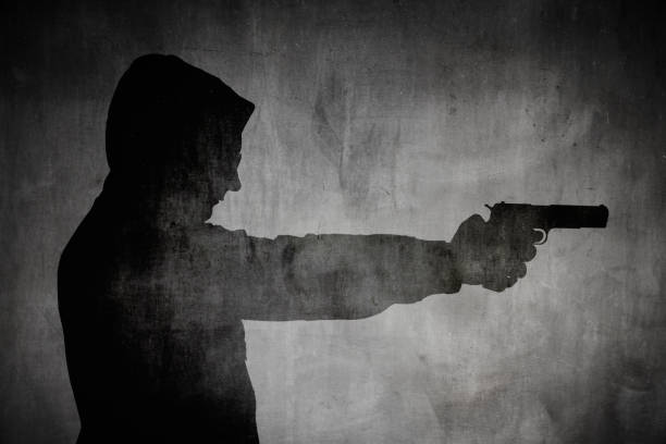 istock Silhouette of a man holding a gun 1144859660
