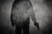 Silhouette of a man holding a gun