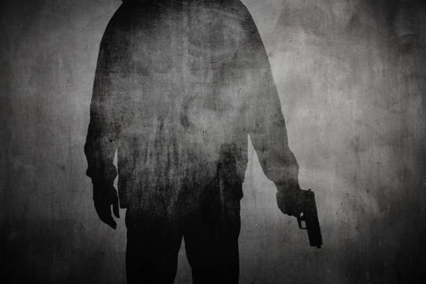 Silhouette of a man holding a gun Silhouette or shadow of a man holding a gun gun stock pictures, royalty-free photos & images