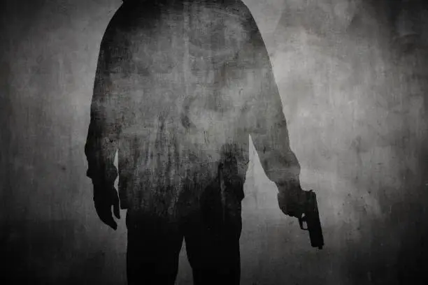 Silhouette or shadow of a man holding a gun