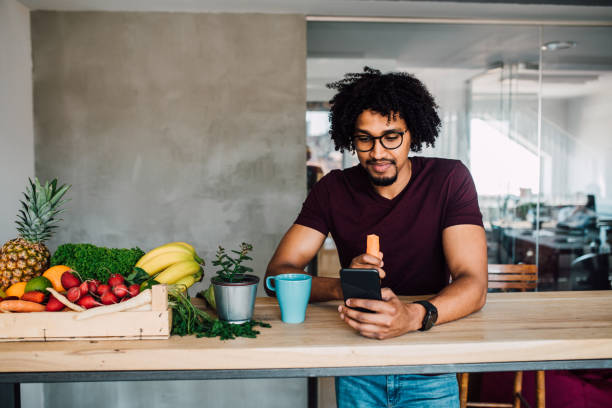 istock Young man eating carrot and using phone 1144859789