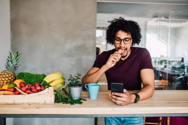 istock Man eating carrot and using mobile phone 1144859809