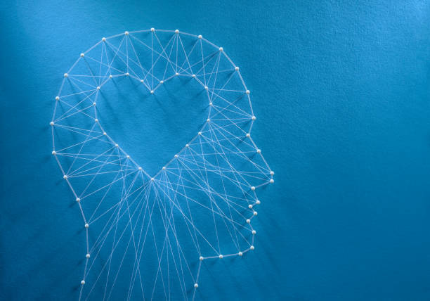 Developing emotional intelligence concept Learning to love concept. Network of pins and threads in the shape of a cut out heart inside a human head symbolising that love is the core of our being and has its own logic. empathy stock pictures, royalty-free photos & images