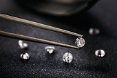 Gemstone clamped in tweezers. Jewelry inserts closeup