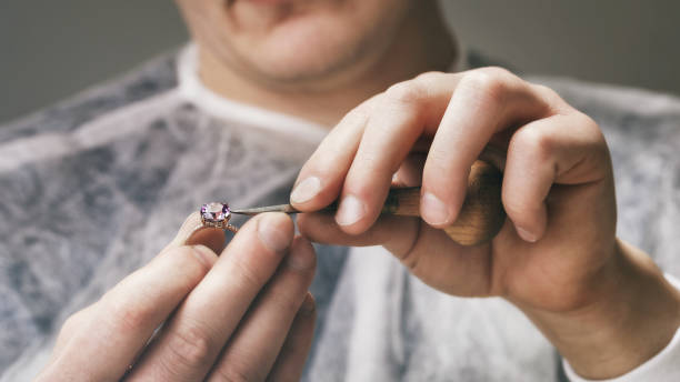 Jeweler fixes stones in a gold ring, close-up Jeweler fixes stones in a gold ring, close-up jewelry craftsperson craft jeweller stock pictures, royalty-free photos & images