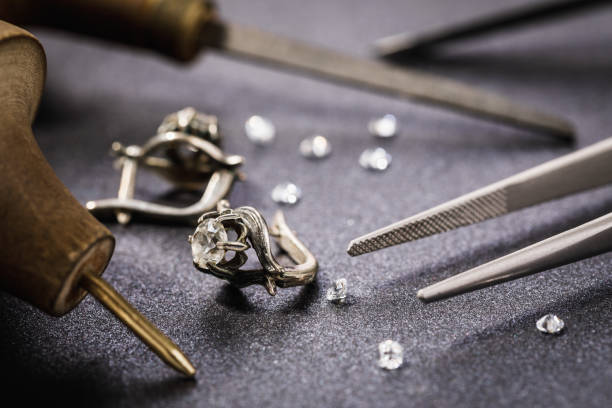 Earrings with a stone on the table, surrounded by tools for the repair of jewelry stock photo