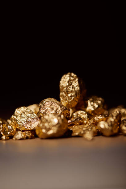 istock golden stones on grey background isolated on black 1144867412