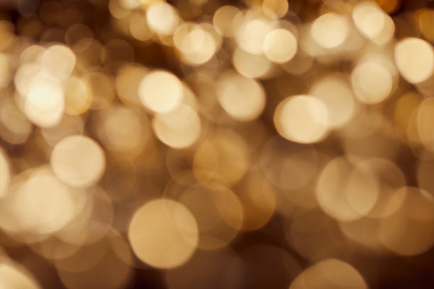 istock dark background with bright blurred golden twinkles and sparkles 1144867515