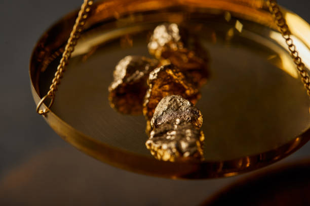 istock selective focus of golden stones on scales on grey background 1144867588