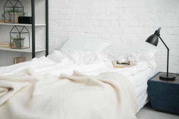 istock Bedroom with rack, white bed and lamp on nightstand 1144867638