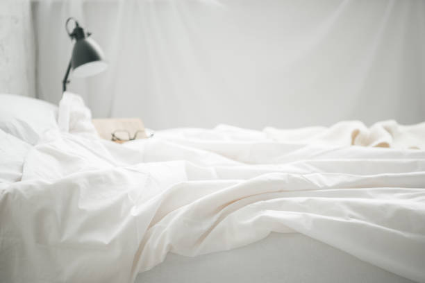 istock Selective focus of glasses on empty white bad and lamp 1144867639